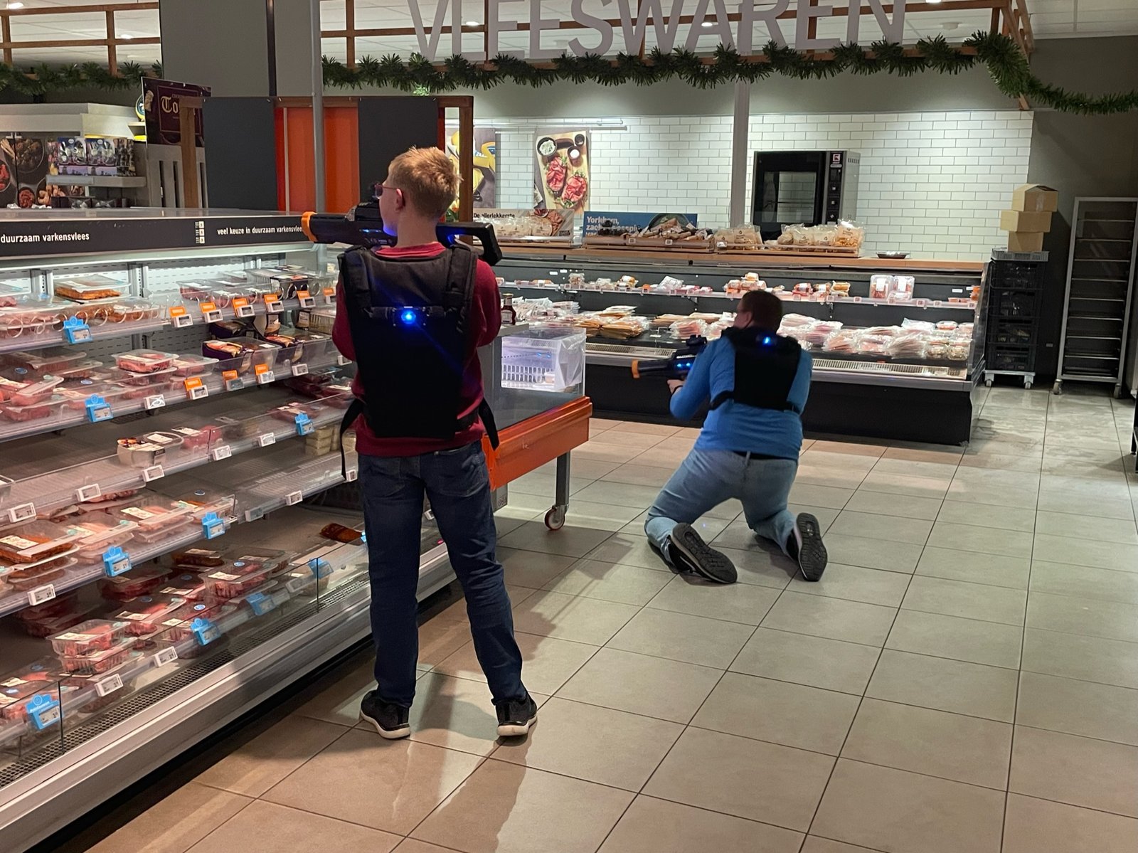 Actievol lasergamen in de gangpaden van een supermarkt na sluitingstijd