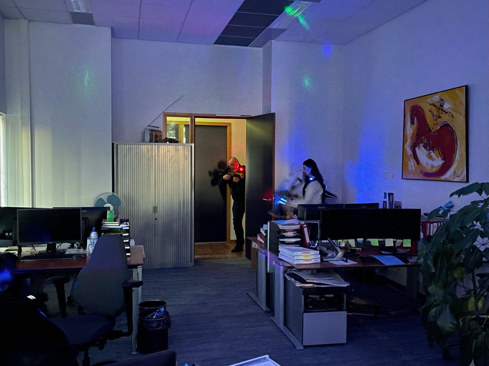 Collega's spelen lasergame tussen de bureaus in een kantoorpand - The Office Battle