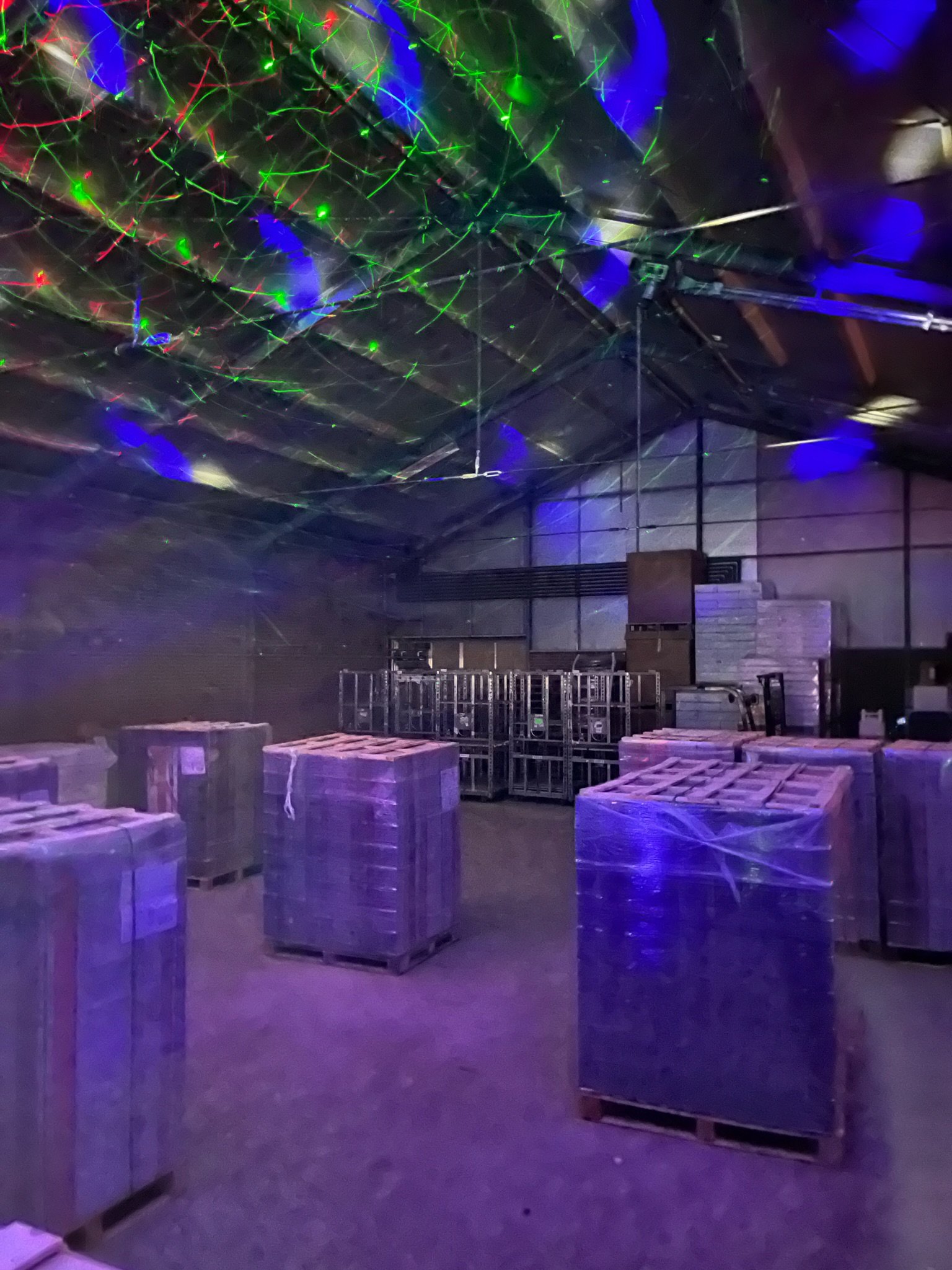 Tactisch lasergamen tussen stellingen en pallets in een groot magazijn